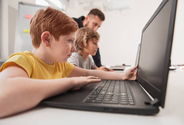 istock Smart boy working on laptop in classroom 1356594684