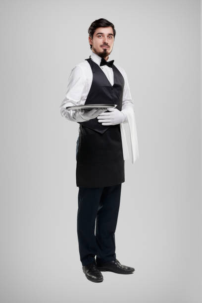 istock Waiter in uniform carrying tray 1356594757
