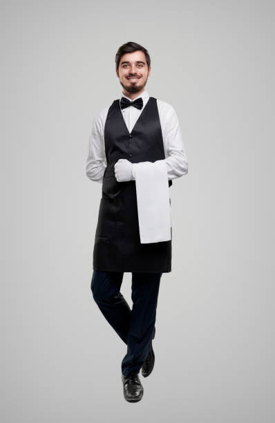 istock Friendly waiter in elegant uniform smiling at camera 1356594783