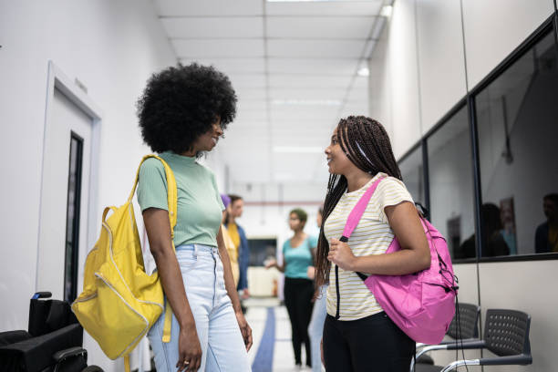 istock Teenage students talking st school corridor 1356598186
