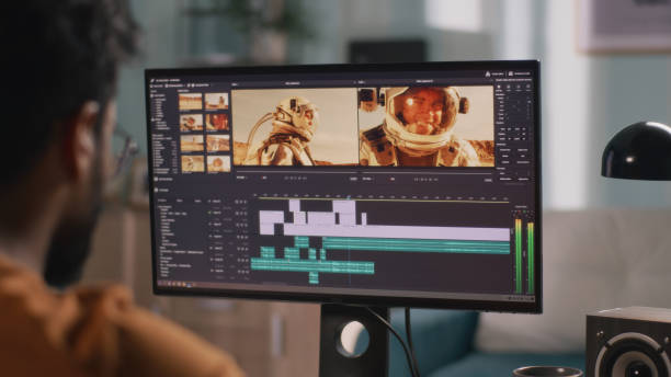 Unrecognizable guy editing astronaut video Back view of male content creator using computer to edit cosmonaut video during remote work from home editing equipment stock pictures, royalty-free photos & images