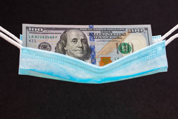 istock surgical mask as hammock with 100 dollar banknotes 1356600146