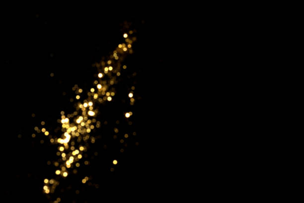 istock Golden blurred bokeh lights on black background 1356600162