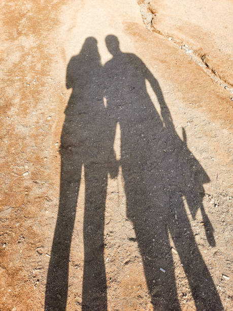 istock shadow of tourists on the beach sand 1356605375
