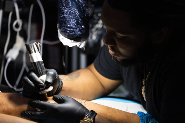 istock Tattoo master is busy with work at tattoo studio. Close up. 1356609186