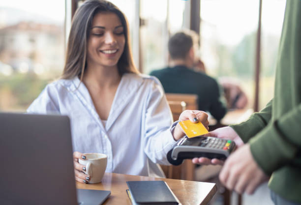 istock Businesswoman Making Credit Card Payment While Working In Cafe 1356611941