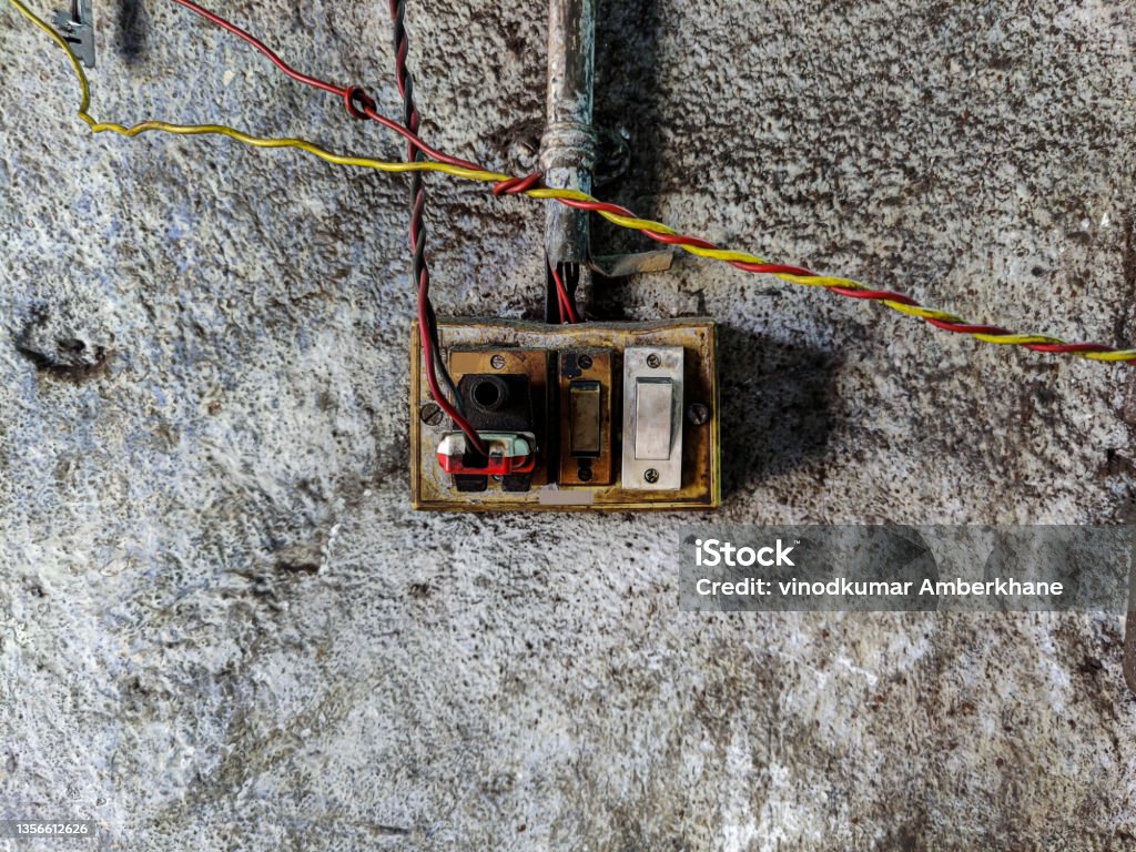 Stock photo of vintage damaged dirty light switch on white color painted wall at abandoned building Kolhapur, Maharashtra, India. focus on object. Kolhapur Stock Photo