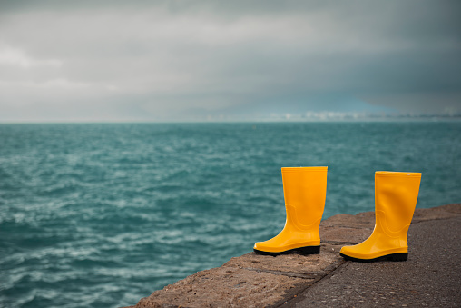 Yellow rain boots in rainy weather landscape