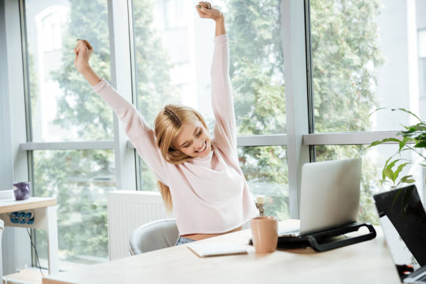 istock Happy lady sitting in office coworking while using laptop 1356618395