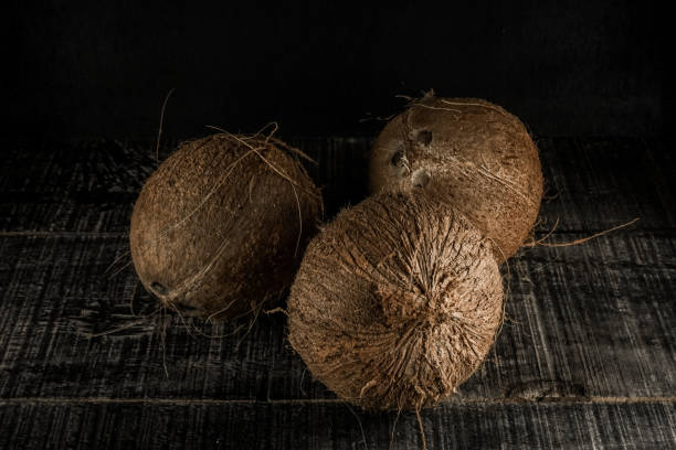 istock Uncoated old coconut fruit on a black background 1356618484
