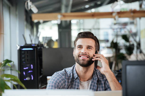 istock Man in office coworking while talking by mobile phone. 1356618954