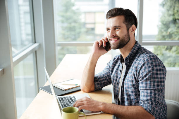 istock Happy man in office coworking talking by phone. 1356619142