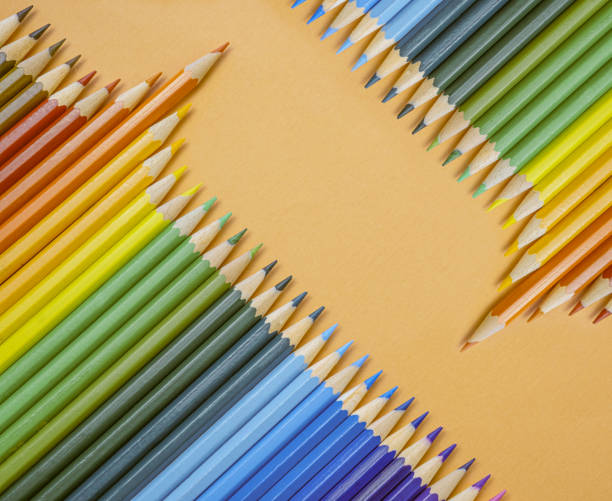 istock Closeup of colored pencils lined up in a row  and abstract shape on background copy space 1356619393