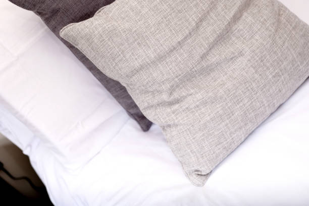 istock close up of grey and white cushions on bed 1356619886