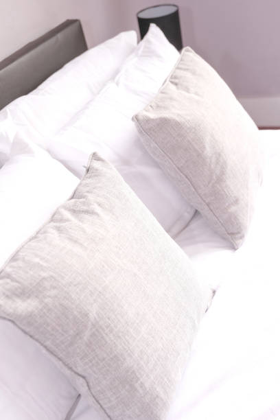 close up of grey and white pillows an cushions on a bed stock photo