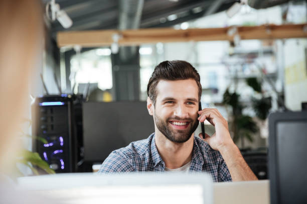 istock Man in office coworking while talking by mobile phone. 1356620773