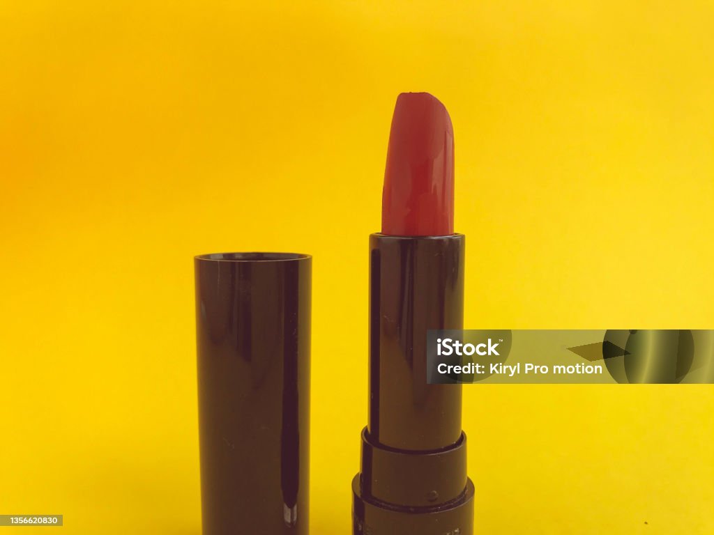 lipstick in a black compact package on a yellow matte background. bright red lipstick, shade creation, lip hydration. stylish and trendy shade lipstick in a black compact package on a yellow matte background. bright red lipstick, shade creation, lip hydration. stylish and trendy shade. Hair Dye Stock Photo