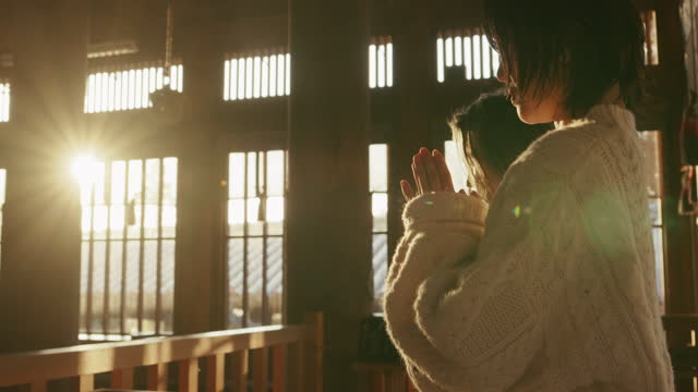MCU- Senior woman and her daughter praying at a Japanese temple for Hatsumode
