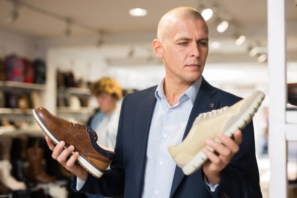 istock Male shopper comparing two moccasins models in shoe store 1356622174