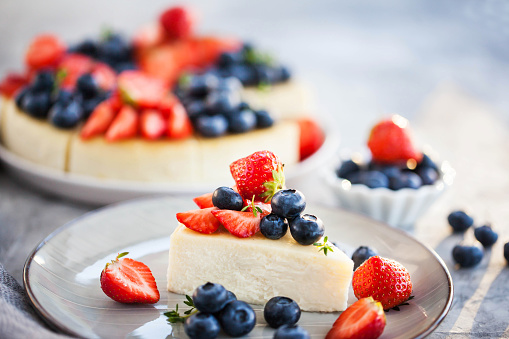 Vanilla New York cheesecake decorated with fresh blueberries and strawberries