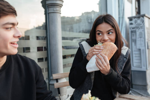 istock Young woman eating burger 1356625112