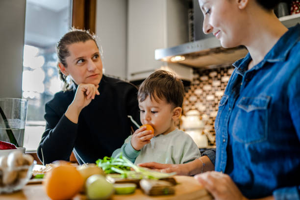 istock Same sex couple and their child preparing dinner in kitchen 1356630656