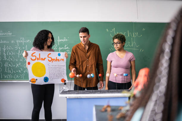 élèves faisant une présentation sur le système solaire en classe - presentation poster student classroom photos et images de collection