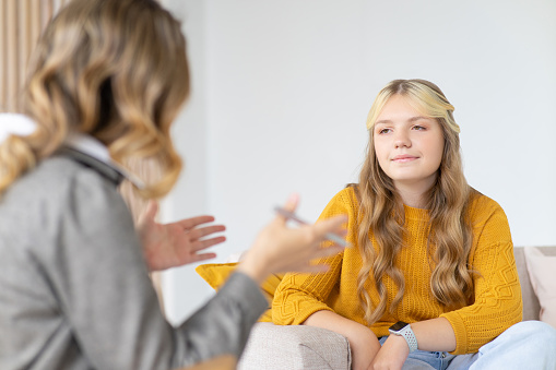 Psychologist woman consults teenage girl. Psychologist session.