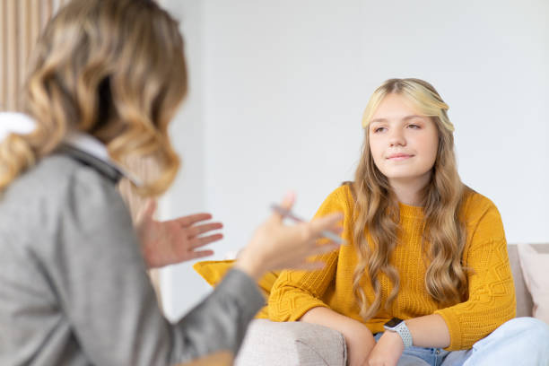 psycholog kobieta konsultuje się z nastolatką. sesja psychologa. - talking chair two people sitting zdjęcia i obrazy z banku zdjęć