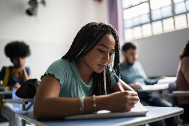 istock Teenage student writing in the classroom 1356630975