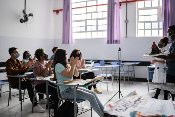 des élèves adolescents applaudissent leurs collègues après une présentation en classe - en utilisant un masque facial - presentation poster student classroom photos et images de collection