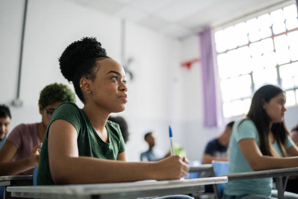 istock Teenage student writing in the classroom 1356631010
