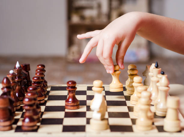 kind, vorschulkind, spielt begeistert holzschach - concentration chess playing playful stock-fotos und bilder