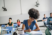 istock Female student taking notes during class 1356632855