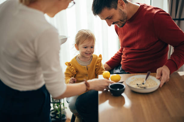czas rodzinny: rodzice i ich jedyne dziecko jeść razem śniadanie - niemowlęta jedyne zdjęcia i obrazy z banku zdjęć