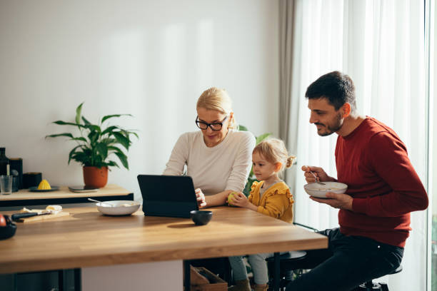 istock Family With One Child Watching Something on the Tablet While Having Breakfast 1356633093