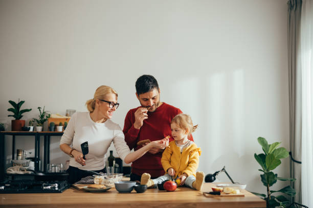 istock Cheerful Parents and Their Daughter Tasting Food While Making Desert 1356633101