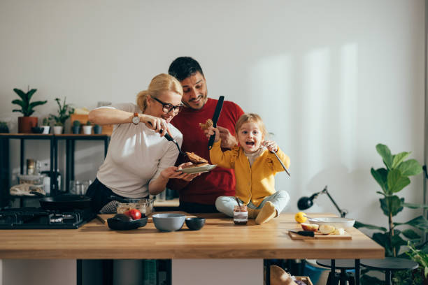 istock Parents and Their Daughter Having Fun While Making Pancakes in the Morning 1356633118