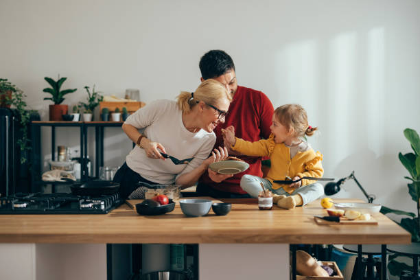 istock Parents and Their Daughter Having Fun While Making Pancakes in the Morning 1356633123
