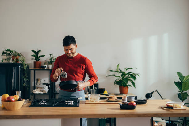 istock Man preparing a meal at home 1356633128