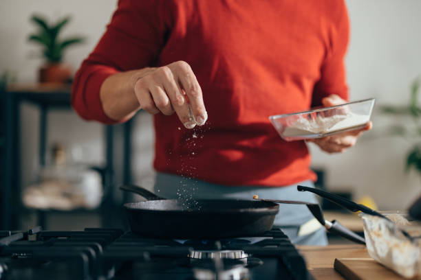 Close Up of Anonymous Man Adding Salt to a Meal Anonymous man is preparing a meal. He is adding salt to a pan with his fingers. salt stock pictures, royalty-free photos & images