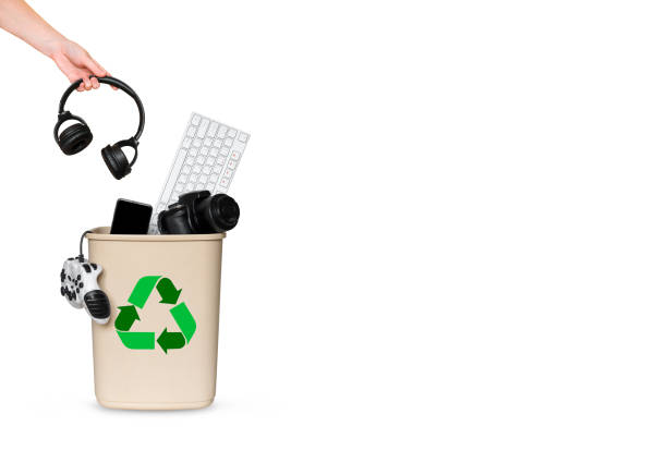 hand throws headphones in a bucket with other gadgets for recycling - environmental damage audio imagens e fotografias de stock