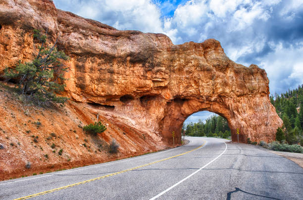 Red Arch road tunnel to Bryce Canyon Red Arch road tunnel leading to Bryce Canyon. Utah, USA bryce canyon stock pictures, royalty-free photos & images