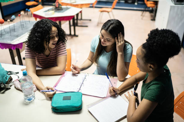 istock Teenage students doing homework together in the classroom 1356636849