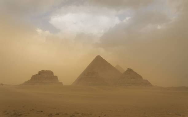 vue panoramique des 3 pyramides de gizeh lors d’une tempête de sable et d’une charrette à cheval - oasis sand sand dune desert photos et images de collection