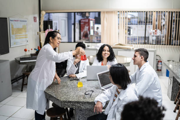 senior teacher teaching teenage students in the laboratory - professor scientist chemistry teacher imagens e fotografias de stock