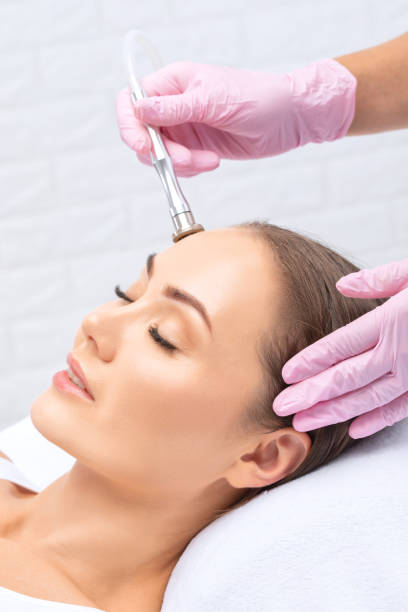 il cosmetologo effettua la procedura microdermoabrasione della pelle del viso di una bella ragazza in un salone di bellezza. cosmetologia e cura professionale della pelle. - dermatology dermabrasion surgery medical foto e immagini stock