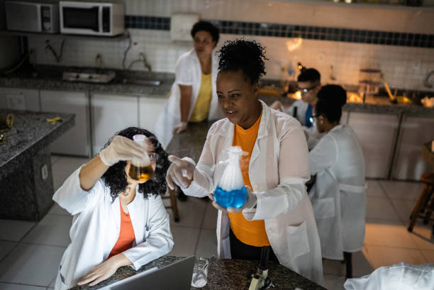 teacher and student doing an experiment in the lab at school or university - professor scientist chemistry teacher imagens e fotografias de stock