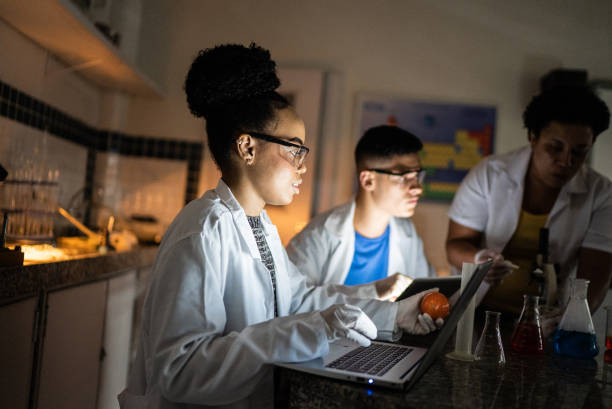istock Chemistry teacher teaching students in the lab at school or university 1356639753