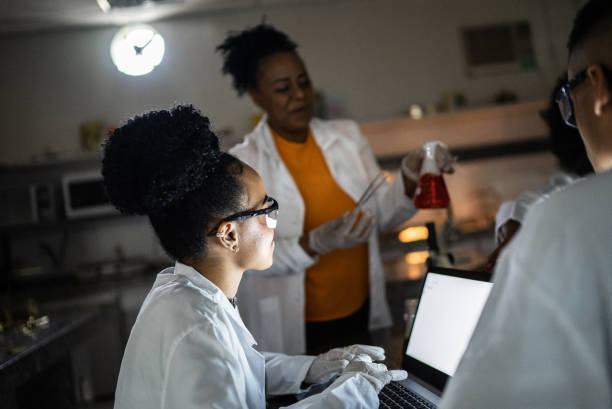 istock Chemistry teacher teaching students in the lab at school or university 1356639938